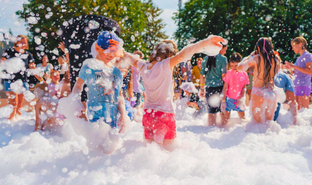 bambini che giocano con la schiuma per festa di compleanno schiuma party